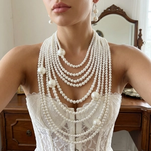 Elegante conjunto de collar de perlas de varias capas y pendientes largos en modelo