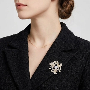 Elegant gold butterfly brooch with pearls and cubic zirconia on a tweed jacket