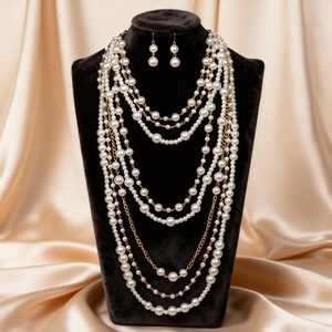 Detalle del collar de perlas de varias capas y pendientes largos en busto negro