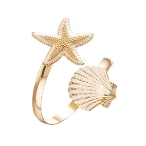 Detailed close-up of a gold starfish and scallop shell ring with cream enamel finish