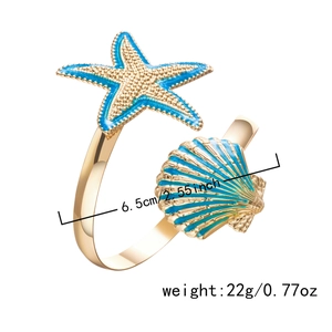 Close-up of golden starfish napkin ring with blue enamel and crystal details