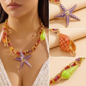 Detail of bohemian gold chain necklace with colorful starfish and seashell charms
