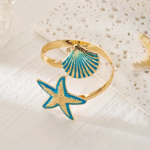 Detailed shot of gold starfish napkin ring with blue enamel sea shell accents