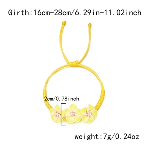 Detailansicht eines gelben geflochtenen Armbands mit drei Plumeria-Blütenanhängern