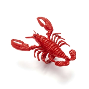 Macro shot of vivid red lobster-shaped ring with glossy finish on a white background