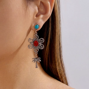 Close-up of bohemian silver drop earrings with turquoise and red stone on model