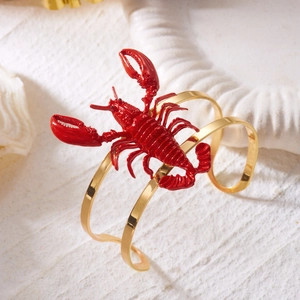 Bold golden cuff bracelet with large 3D red lobster centerpiece on marine decor