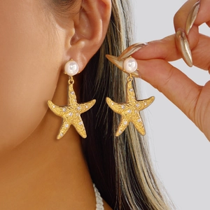 Detailed close-up of gold starfish earrings featuring pearls and sparkling rhinestones