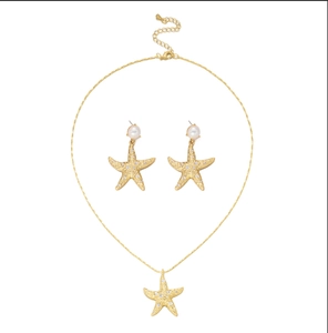 Close-up of golden starfish jewelry set with sparkling rhinestones and white pearls