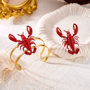 Detail of creative red lobster bangle with polished golden metal and 3D textured carving