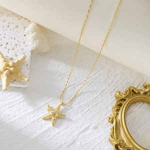 Detail shot of golden starfish necklace with white rhinestones and ocean style props