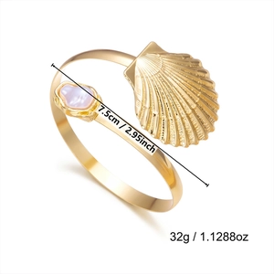 Detail showing shell arm cuff dimensions 7.5cm and weight 32g in gold finish