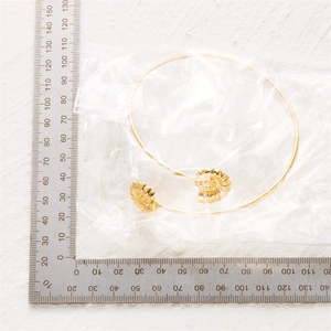Detailed close-up of a gold bohemian cuff armlet with shell and nautilus ornaments