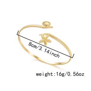 Detail view of gold starfish and seashell arm cuff showing size 8cm and 16g weight