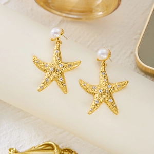 Detail of golden starfish earrings featuring white pearls and shimmering rhinestones