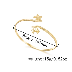Detail view of a gold bohemian arm cuff with starfish and crab charms, 8cm diameter