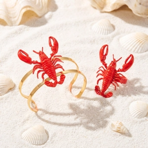 3D red lobster jewelry set with gold cuff bracelet and matching ring on beach sand