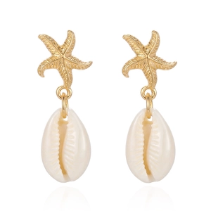 Detailed close-up of golden starfish and white seashell earrings with textured metal finish