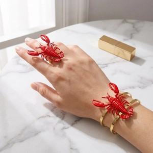 Detailed view of vivid red 3D lobster ring and bracelet set on a golden band