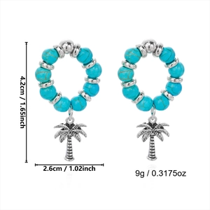 Detail view of bohemian hoop earrings with turquoise beads and silver palm tree pendants