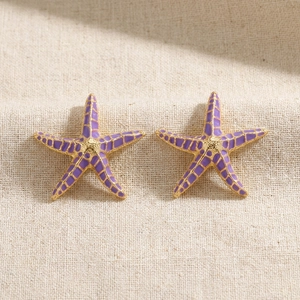 Detailed close-up of purple starfish earrings with gold metal edges and grid texture