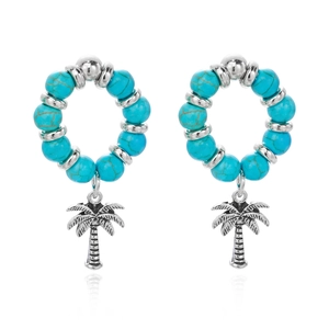 Detailed macro view of bohemian turquoise bead earrings with silver palm tree pendants