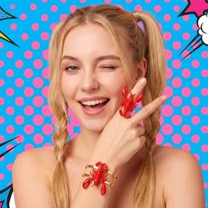Close-up of 3D red lobster jewelry set including a ring and golden bangle on model