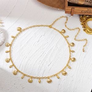 Détail de la chaîne de taille dorée avec pendentifs coquillages et fermoir mousqueton