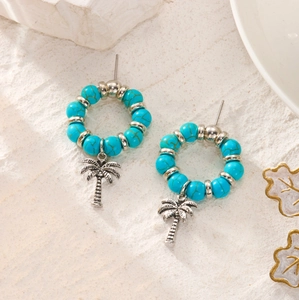 Detailed close-up of turquoise beaded hoop earrings with silver palm tree pendants