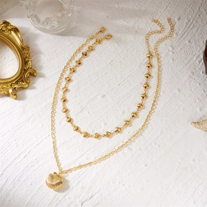 Double-layered gold seashell necklace with small scallop pieces and large 3D shell pendant