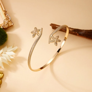 Detail of golden starfish cuff bracelet showing intricate woven texture and sea star motifs