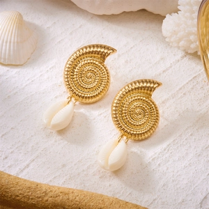 Detailed view of spiral gold metallic earrings with natural white shell pendants