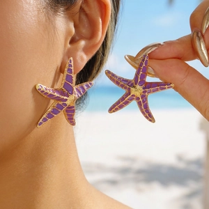 Bohemian gold starfish earrings with purple enamel detailing for a stylish summer beach look