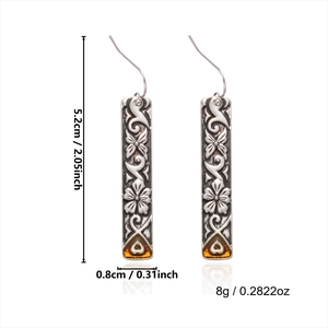 Detailed view of silver flower earrings with amber heart pendants, 5.2cm long