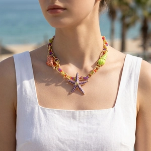 Detail of bohemian gold chain necklace with colorful sea stars and shell pendants