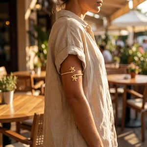 Detail of bohemian gold starfish upper arm cuff worn by a model in a summer setting