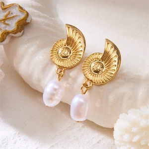Detailed view of vintage gold conch shell earrings featuring baroque pearls on white coral