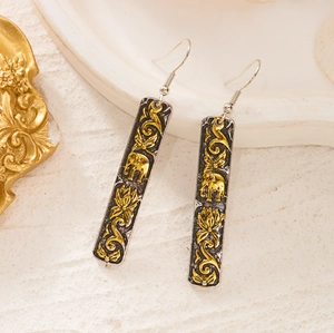 Detailed close-up of retro ethnic drop earrings featuring golden elephant and lotus reliefs