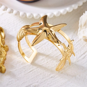 Macro detail of a golden starfish armlet with detailed seashell motifs and a polished finish
