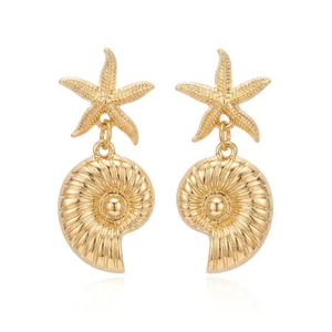 Detail of gold starfish and shell pendant earrings with intricate textured engravings