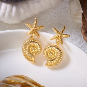 Close-up of golden starfish and spiral seashell drop earrings with detailed textures