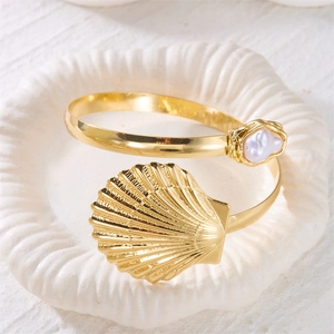 Golden bohemian shell arm cuff bracelet featuring large scallop shell and baroque pearl