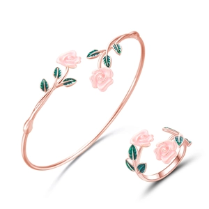 Detail van roségouden armband en ring set met roze emaille bloemen en groene bladeren