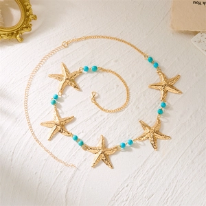 Détail de la chaîne de taille étoile de mer dorée avec perles bleues et fermoir