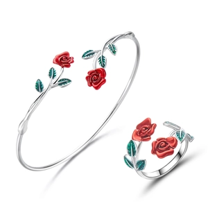 Detail van rode emaille rozenarmband en bijpassende ringenset in zilverkleur