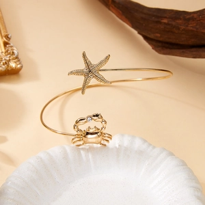 Gros plan sur le bracelet de bras étoile de mer dorée et crabe avec zircon brillant