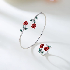 Detail van de verstelbare zilveren armband en ringenset met rode geëmailleerde rozen