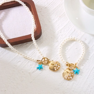 Detail of bohemian pearl jewelry set with starfish pendants and golden toggle clasp