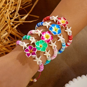 Detailed view of 5-piece Bohemian beach bracelet set with plumeria charms and heishi beads