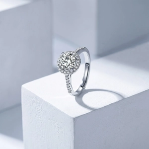 Macro detail of silver adjustable ring with round halo diamond setting on white cubes